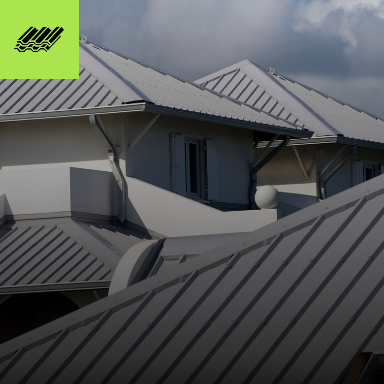 Modern metal-roofed houses under cloudy sky.